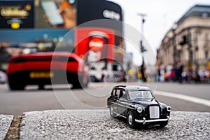 Closeup shot of a traditional black cab driving through the most famous landmarks in London