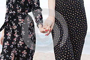 Closeup shot of two caucasian females holding hands showing the girl's day concept