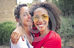 Closeup shot of two friends smiling while taking pictures outdoors