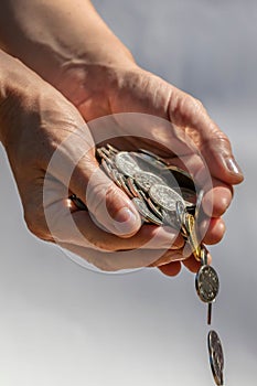 Closeup shot of two hands full of Canadian cash coins and dropping them