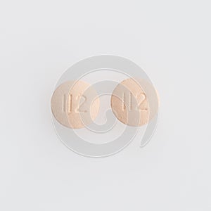 Closeup shot of two round medical pills isolated on a white background