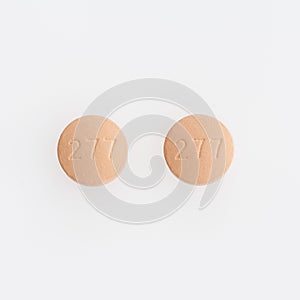 Closeup shot of two round medical pills isolated on a white background