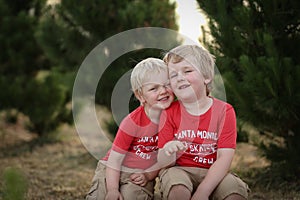 Closeup shot of two white Caucasian kids with blond hair bonding with each other