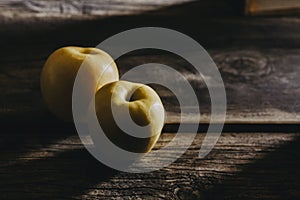 Closeup shot of the two yellow apples under the sunlight isolated on a wooden surface