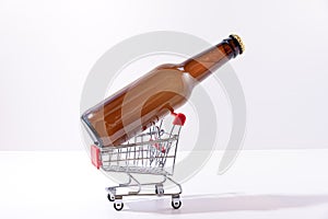 Closeup shot of an unlabelled bottle of beer in a small metal shopping cart