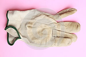 Closeup shot of used leather work gloves in color background