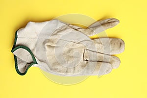 Closeup shot of used leather work gloves on a yellow background