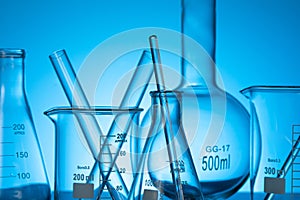 Closeup shot of a variety of glass flasks and lab equipment on a blue background