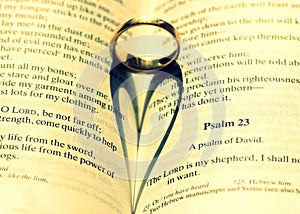 Closeup shot of a wedding ring on the Bible making a beautiful heart illustration