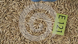 Closeup shot of wheat grains background, hand in glove puts paper sign with E 121 written on it. HDR BT2020 HLG Material