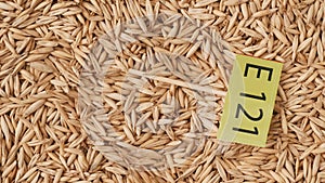 Closeup shot of wheat grains background and paper with E 121 written on it.