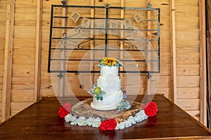 Closeup shot of a white cake on a wooden table with Mr. and Mrs. on the wall