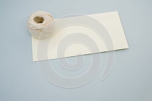 Closeup shot of white cord rope on a piece of paper on gray background