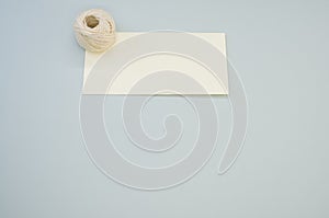 Closeup shot of white cord rope on a piece of paper on gray background