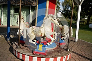 Closeup shot of white horses on a children's carousel