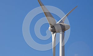 Closeup shot of a wind turbine on the background of heaven on a sunny day