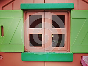 Closeup shot of a window of pink and green dollhouse
