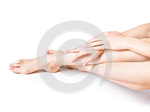 Closeup shot of a woman applying moisturizer to her leg and feet. Beauty feet and hands isolated on white background