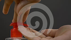 Closeup shot of a woman hands using a hand sanitizer dispenser - hygiene concept