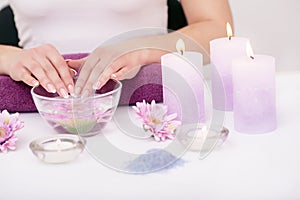 Closeup shot of a woman in a nail salon receiving a manicure by