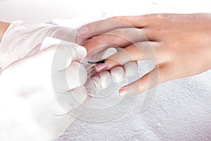 Closeup shot of woman in a nail salon. Receiving a manicure by a beautician