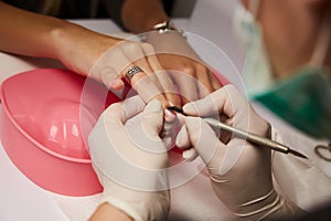 Closeup shot of a woman in nail salon receiving manicure by beautician with file. getting . nails to customer.