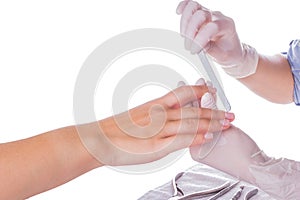 Closeup shot of a woman in a nail salon receiving a manicure by a beautician with nail file