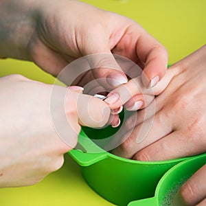 Closeup shot of a woman in a nail salon receiving a manicure by a beautician with nail file. Woman getting nail manicure. Beautici