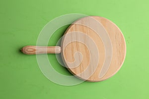 Closeup shot of a wooden chopping board  isolated on a green background