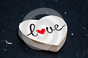 Closeup shot of a wooden heart decoration with "Love" written in it, the concept of romantic moments