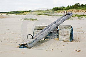 Closeup shot of a wooden teeter totter in the beach