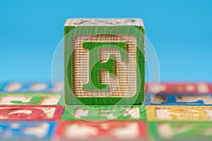 Closeup shot of the wooden toy block with the letter F for learning the alphabet