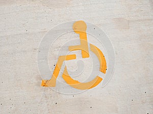 Closeup shot of a yellow handicapped sign painted on the wall