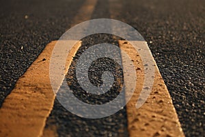 Closeup shot of yellow marking lines on an asphalt road