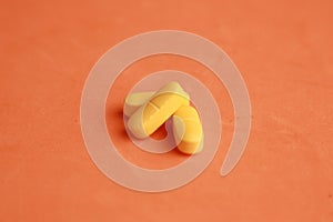 Closeup shot of yellow pills on an orange background
