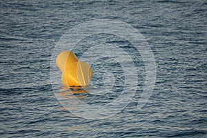 Closeup shot of a yellow swim limit signaling buoy in the sea