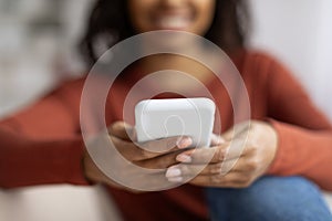 Closeup shot of young black woman using her smartphone at home