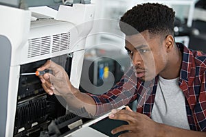 closeup shot young male technician repairing digital photocopier machine