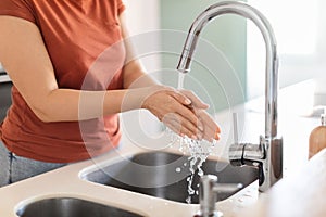 Closeup Shot Of Young Woman Washing Hands In Kitchen Sink