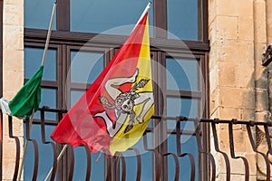 Closeup show of the flag of Sicily with triskeles symbol, head of Medusa, pair of wings and three wheat ears waving