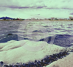 Closeup shows foam on Beck Lake in Cody, Wyoming. Waves are dark blue with bubbles.