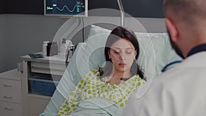 Closeup of sick woman with nasal oxygen tube resting in bed