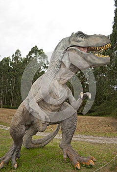 Closeup and side profile view of a fierce Tyrannosaurus Rex in a forest background