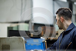 Closeup side view of early 30`s male employee at a factory