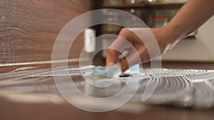 Closeup side view of unrecognizable man with cleaning induction stove in kitchen. Closeup hands of housewife wiping