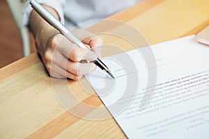 Closeup of signing a documentation agreement and pen on the table.