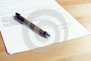 Closeup of signing a documentation agreement and pen on the table.