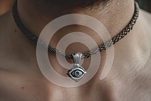 closeup of a silver thirdeye pendant around a neck
