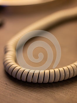 Closeup of single curved spiral cable white wire. Phone line