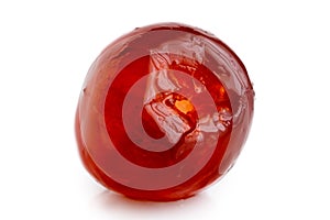 Closeup of a single red glace cherry isolated on white.